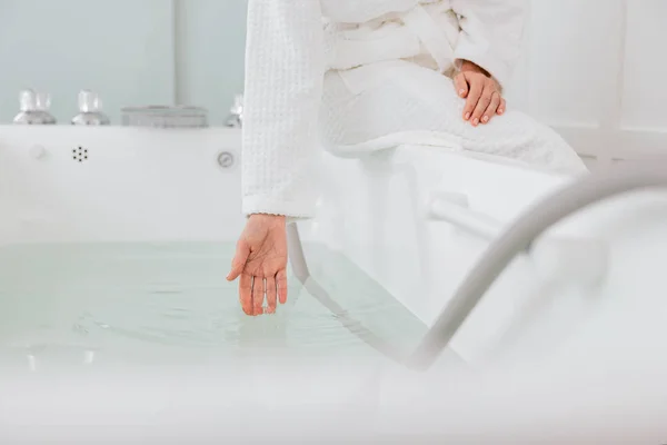 Крупним планом жінка рука торкається води в гідромасажній ванні — стокове фото