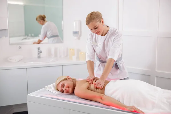 Dame souriante recevant un massage du dos d'un masseur dans un spa — Photo