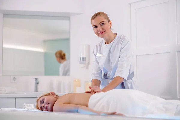 Glimlachende vrouw liggend op relax massage tafel — Stockfoto