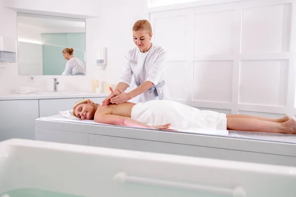 Female masseur doing massage on lady body in spa salon — Stockfoto