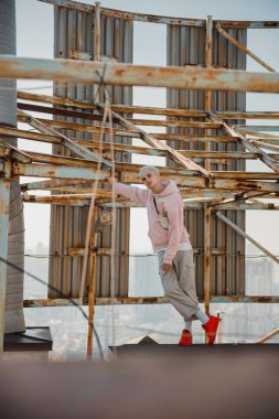 Çatıdaki kameraya poz veren şık erkek.