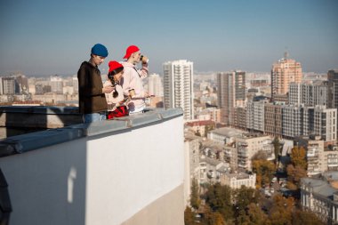 Genç arkadaşlar çatıda kahveyle duruyorlar.