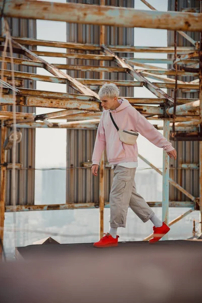 Young male staying against the background of metal structures — Stock Photo, Image