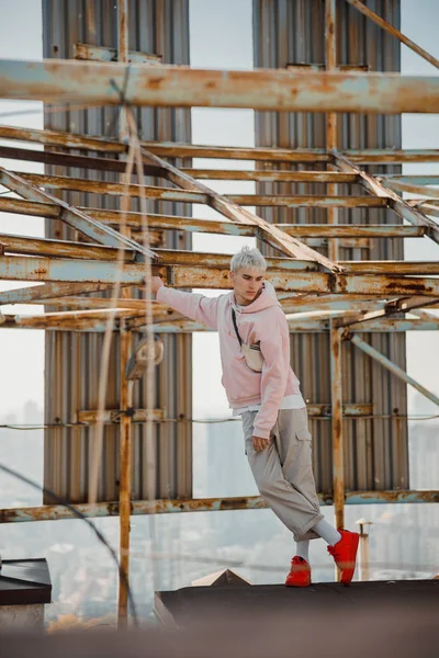 Jeune homme posant près de la structure métallique sur le toit — Photo