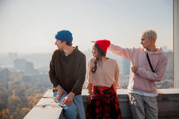 Young guy showing hand to side on the roof — ストック写真