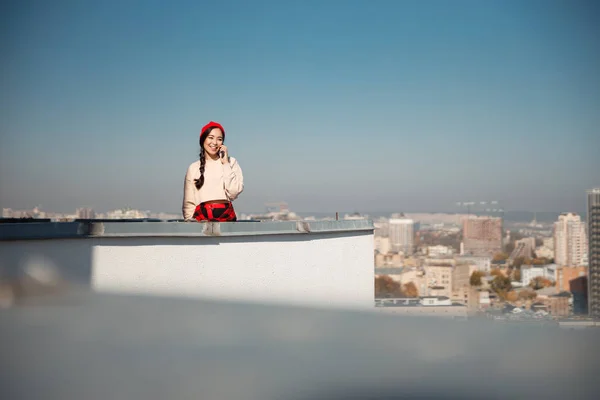 Όμορφη χαμογελαστή κυρία χρησιμοποιώντας smartphone, ενώ διαμένουν στην οροφή — Φωτογραφία Αρχείου