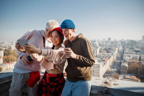 Милая азиатка делает селфи со своими друзьями на крыше — стоковое фото
