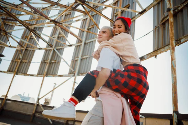 Glücklich hübsche Dame umarmt ihren Freund auf dem Dach — Stockfoto
