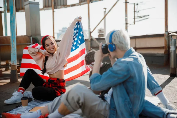 Feliz chica asiática sentada con bandera en el techo — Foto de Stock