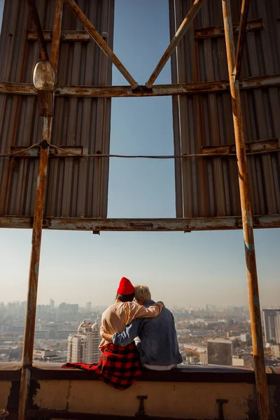 Lovelr jovem casal sentado juntos e olhando para a vista da cidade — Fotografia de Stock