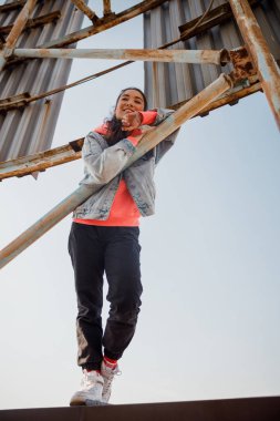 Güzel, gülümseyen kadın çatıda duruyor.