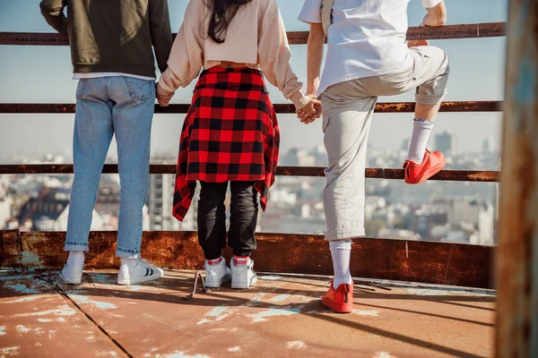 Young friends holding hands on the roof — Stock Photo, Image