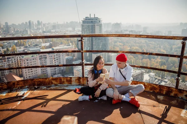 Улыбающиеся парень и девушка смотрят на сэндвичи на крыше — стоковое фото