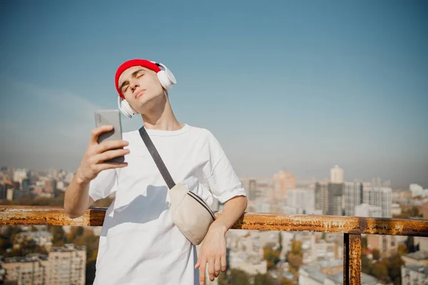 Stylish young man using smartphone on the roof — Stock Photo, Image