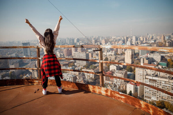 Girl holding hands up on the rooftop stock photo