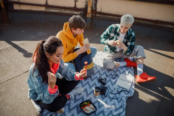 Amigos felices sostienen comida en el techo — Foto de Stock