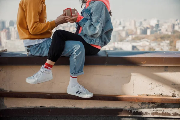 Menina sentada perto de seu namorado no telhado — Fotografia de Stock