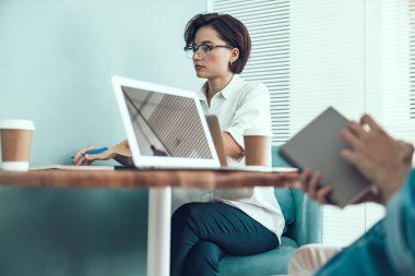 Ofiste iş arkadaşının yanında oturan genç kadın.