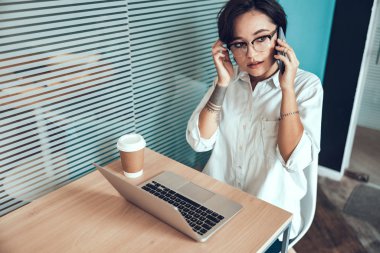 Genç bayan akıllı telefondan ciddi bir konuşma yapıyor.