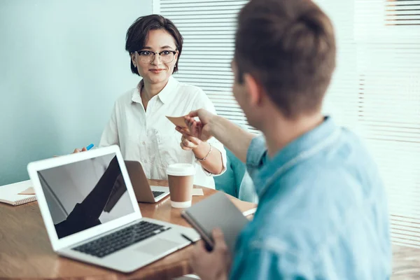 Mujer sonriente está mirando a su colega — Foto de Stock