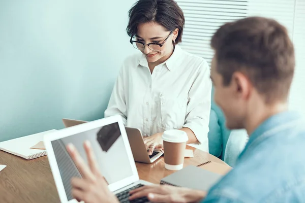 Mujer sonriente está escribiendo en el ordenador portátil en la oficina — Foto de Stock