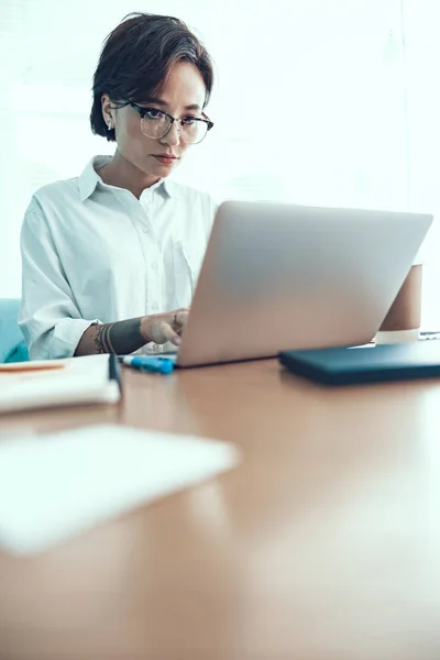 Mujer joven está escribiendo en su computadora portátil — Foto de Stock