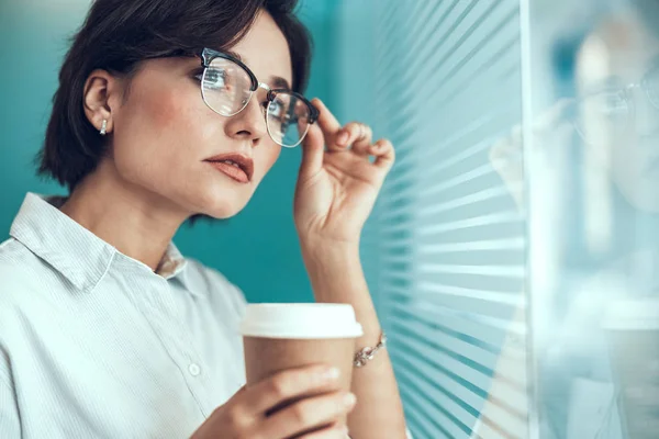 Söt ung kvinna rör sina glasögon — Stockfoto