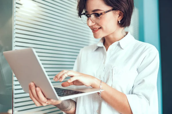 Leende ung kvinna skriver på laptop — Stockfoto