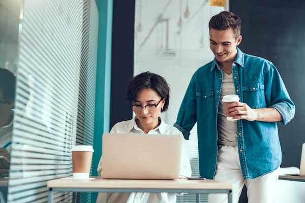 Dos colegas mirando la pantalla de un portátil — Foto de Stock