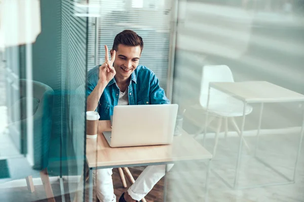 Uomo sorridente che mostra il gesto della mano sul posto di lavoro — Foto Stock