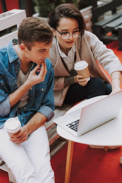 Mujer bonita con café sentado cerca de hombre al aire libre — Foto de Stock