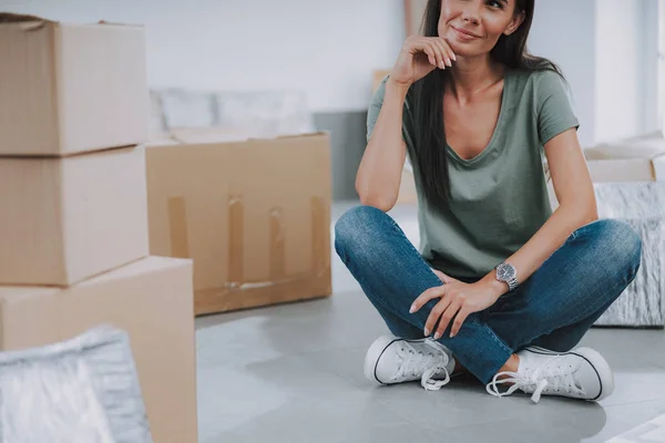 Sonriendo agradable hembra sentada en el piso en el nuevo piso — Foto de Stock