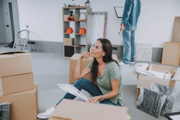 Mujer joven sonriente pensando en el diseño del apartamento — Foto de Stock