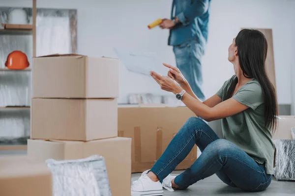 Mujer joven está mostrando el diseño del apartamento para el hombre — Foto de Stock