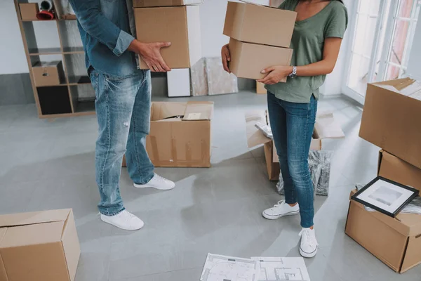 Mies ja nainen, jotka pitävät pahvilaatikoita uudessa asunnossa — kuvapankkivalokuva
