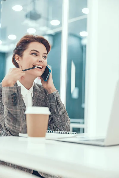 Bijten potlood tijdens de telefoon praten voorraad foto — Stockfoto