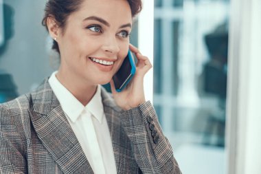 Cep telefonu stoklarında fotoğrafı olan neşeli bir kadın.