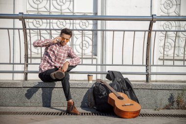 Genç adam şehirde akıllı telefon kullanıyor.