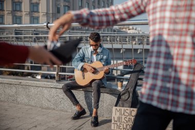 Street musician playing guitar in the city clipart