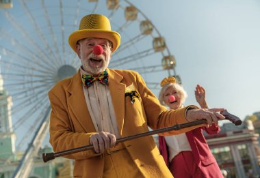 Olgun palyaçolar lunaparkta eğleniyorlar.