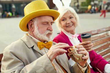 Fast food yiyip içki içen yaşlı bir çift.