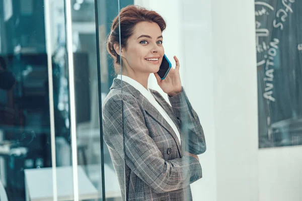 Zufriedene Geschäftsfrau schaut zufrieden auf das Telefongespräch — Stockfoto