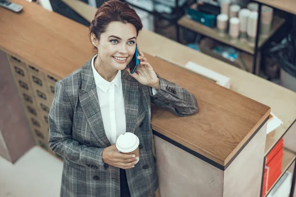 Gelukkige stijlvolle vrouw met koffie glimlachende stock foto — Stockfoto
