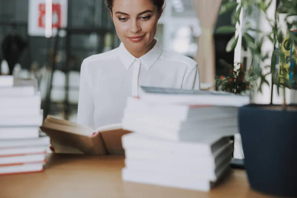 Mujer sonriente con montones de libros stock foto — Foto de Stock