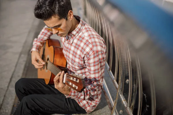 Straßenmusiker blickt auf seine Gitarre — Stockfoto