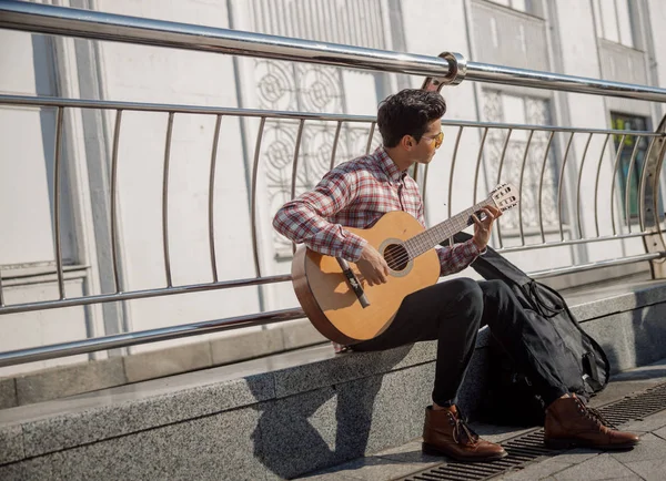 Jovem pegando acordes de guitarra ao ar livre — Fotografia de Stock