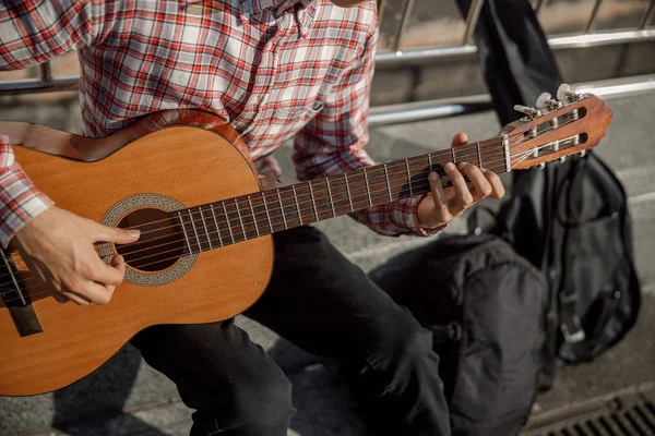 Mãos masculinas segurando guitarra e tocando na rua — Fotografia de Stock