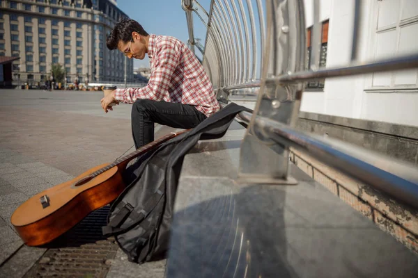 Músico masculino olhando para baixo na cidade — Fotografia de Stock