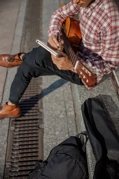 Обрезанное фото гитариста, держащего ноутбук на улице — стоковое фото