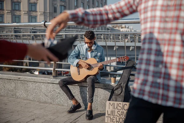 Уличный музыкант играет на гитаре в городе — стоковое фото